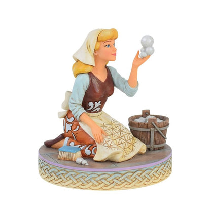 Cinderella-beeldje van Jim Shore waarop ze als dienstmeisje een zeepbel opvangt tijdens het schoonmaken, met verfijnde details die haar kracht, gratie en optimisme uitstralen – een betoverend Disney-verzamelstuk vol hoop en veerkracht.